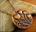Oval pink bronze pendant featuring seed pods and scrolls