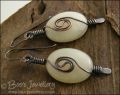 Pale green oval earrings with a dark copper spiral