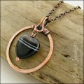 Antiqued copper circle pendant with banded black heart gemstone