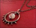 Antiqued copper circle pendant, bud wrapped and with spider web jasper