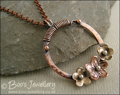 Hammered copper ring with bronze and copper flowers