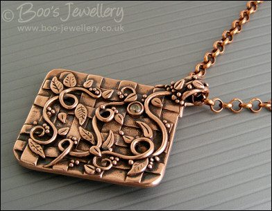 Copper garden trellis pendant festooned with vines and leaves