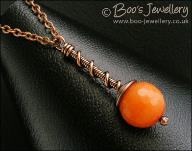 Intense orange coloured faceted jade coil on coil pendant