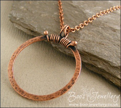 Hammered copper circle pendant with tendril bail