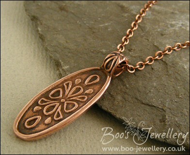 Oval copper pendant with hand drawn geometric design