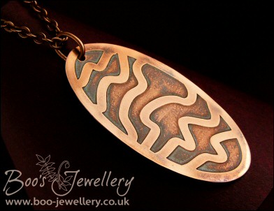 Oval copper pendant etched with random stripes