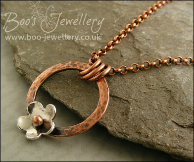 Hammered copper ring pendant with silver flower