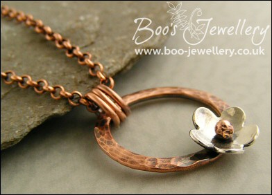 Hammered copper ring pendant with silver flower