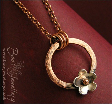 Hammered copper ring pendant with silver flower
