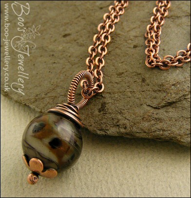 Dark glass and copper wire wrapped pendant on chain