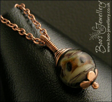 Dark glass and copper wire wrapped pendant on chain