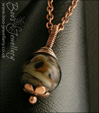 Dark glass and copper wire wrapped pendant on chain