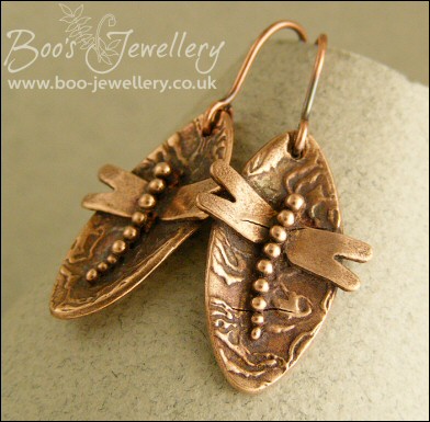Oval antiqued earrings with appliqued dragonfly motif