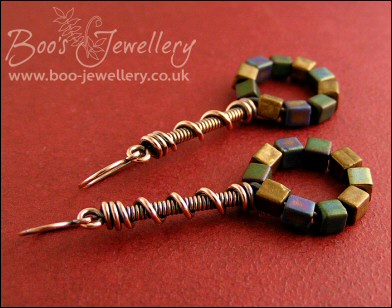 Coil on coil antiqued copper earrings with loop of glass cubes