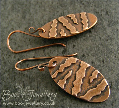Oval antiqued earrings with geometric stripe applique