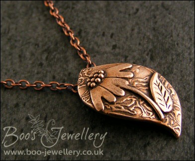 Wave shaped curvy copper pendant with relief daisy design