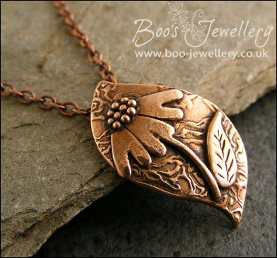 Wave shaped curvy copper pendant with relief daisy design