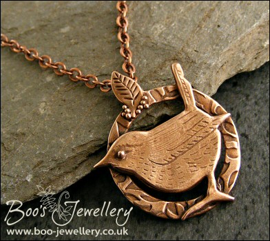 Circle shaped pendant featuring a hand sculpted wren