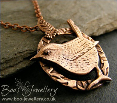 Circle shaped pendant featuring a hand sculpted wren