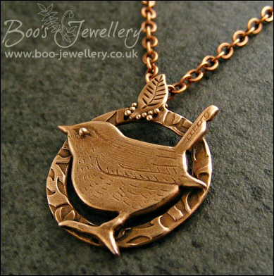 Circle shaped pendant featuring a hand sculpted wren