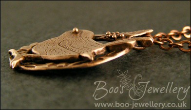 Circle shaped pendant featuring a hand sculpted wren