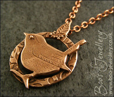 Circle shaped pendant featuring a hand sculpted wren