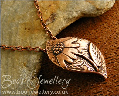 Wave shaped curvy copper pendant with relief daisy design