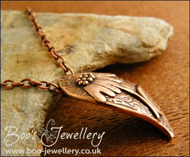Wave shaped curvy copper pendant with relief daisy design