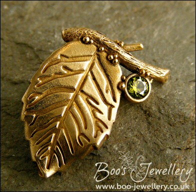 Bronze leaf brooch pin with peridot coloured gemstone