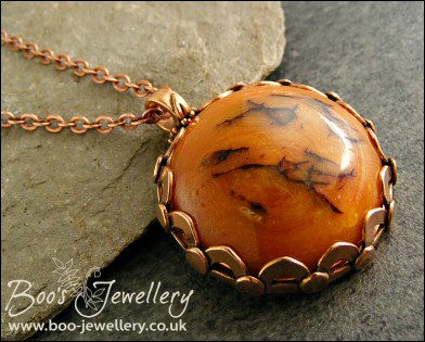 Faux amber cabochon set in a pink bronze bezel pendant