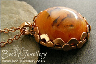 Faux amber cabochon set in a pink bronze bezel pendant