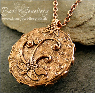 Faux amber cabochon set in a pink bronze bezel pendant