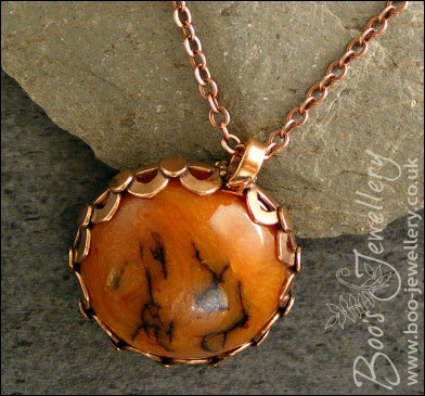 Faux amber cabochon set in a pink bronze bezel pendant