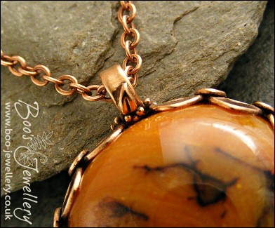 Faux amber cabochon set in a pink bronze bezel pendant