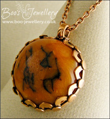Faux amber cabochon set in a pink bronze bezel pendant