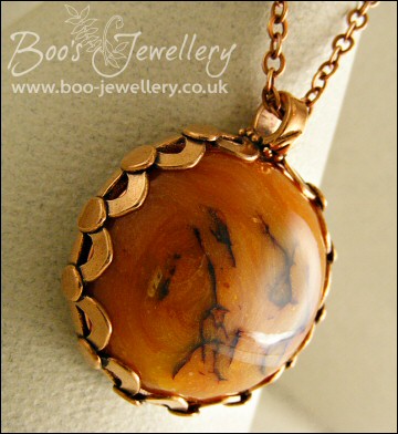Faux amber cabochon set in a pink bronze bezel pendant