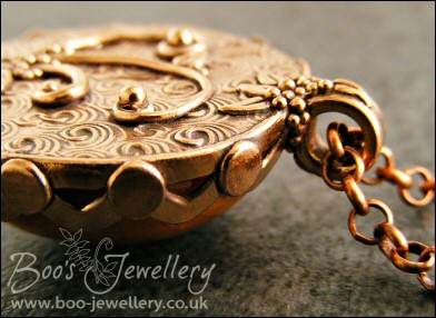 Faux amber cabochon set in a pink bronze bezel pendant