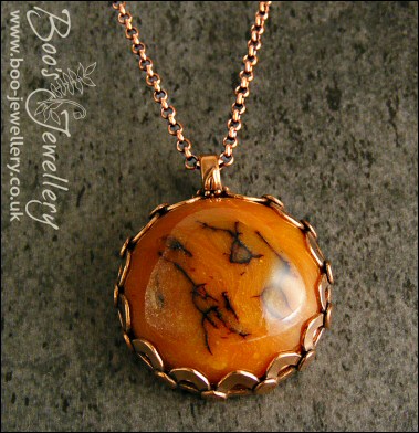 Faux amber cabochon set in a pink bronze bezel pendant