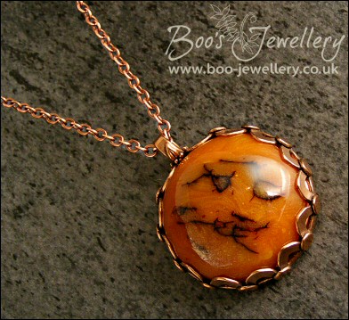 Faux amber cabochon set in a pink bronze bezel pendant