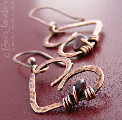Antiqued copper heart earrings wrapped with garnet chips