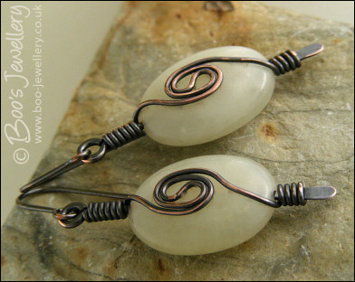 Pale green oval earrings with a dark copper spiral