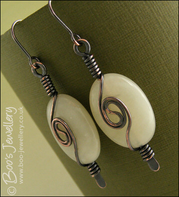Pale green oval earrings with a dark copper spiral