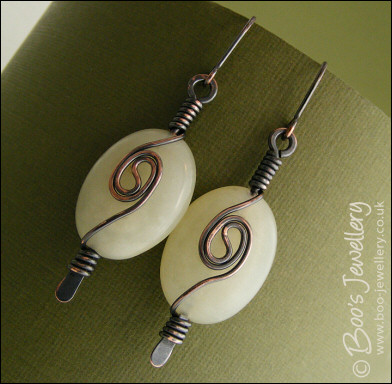Pale green oval earrings with a dark copper spiral