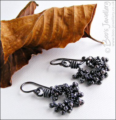 Earrings featuring dark clusters of molten copper