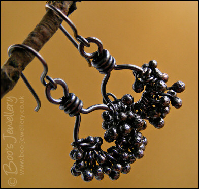 Earrings featuring dark clusters of molten copper