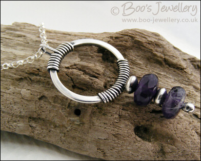 Silver circle pendant wrapped with faceted amethyst rondelles