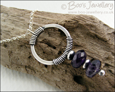 Silver circle pendant wrapped with faceted amethyst rondelles