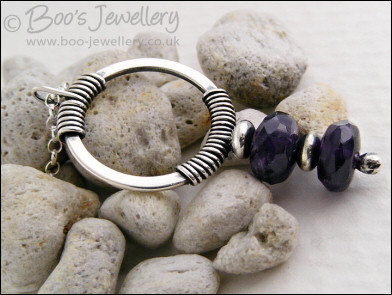 Silver circle pendant wrapped with faceted amethyst rondelles