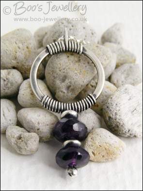 Silver circle pendant wrapped with faceted amethyst rondelles