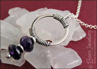 Silver circle pendant wrapped with faceted amethyst rondelles